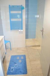 a bathroom with a shower with a blue rug at Banyuls in Latour-Bas-Elne