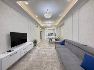 a living room with a couch and a flat screen tv at Grace apt in Bay Tash Tower in Bishkek +13 photos