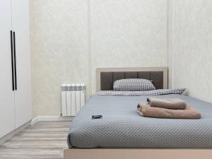 a bedroom with a bed with two pillows on it at Grace apt in Bay Tash Tower in Bishkek