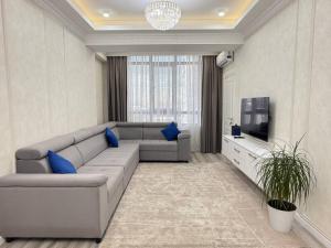 a living room with a couch and a tv at Grace apt in Bay Tash Tower in Bishkek