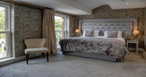 a bedroom with a large bed and a chair at The Lord Street Hotel; BW Signature Collection in Southport