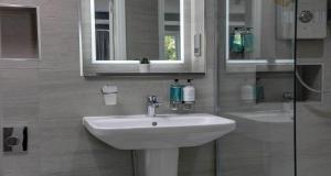 a bathroom with a sink and a glass shower at The Lord Street Hotel; BW Signature Collection in Southport