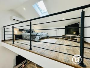 een slaapkamer op zolder met een bed en een open haard bij La detente in Lézignan-Corbières