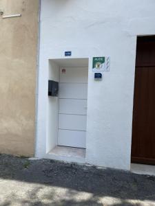 een witte deur met een bord aan de zijkant van een gebouw bij La detente in Lézignan-Corbières