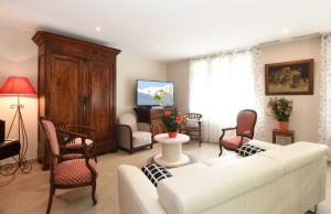 a living room with a white couch and chairs at Les colombelles in Sainte-Colombe
