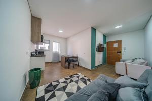 a living room with a couch and a kitchen at Primus House in São Paulo