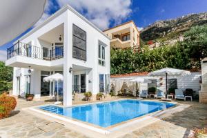 a villa with a swimming pool in front of a house at Villa Dolluca in Kaş