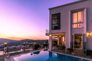 a villa with a swimming pool at dusk at Villa Dolluca in Kaş