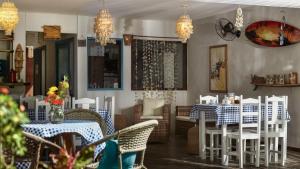 a dining room with tables and chairs and chandeliers at Pousada AGUA SALGADA in Jericoacoara