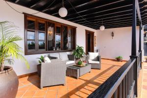 a patio with chairs and a couch on a balcony at El Islote in San Bartolomé