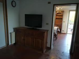 a living room with a television on a wooden dresser at casa con vista e piscina nelle colline della Versilia in Stiava