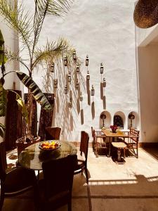 a room with tables and chairs and a wall with lights at Riad la Cigale in Marrakesh