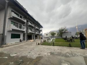 锡卡都Eat and Read Hotel的一名男子站在一栋建筑物前