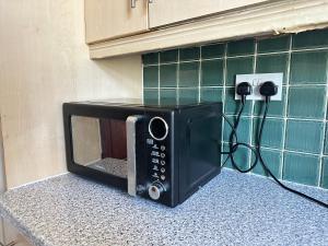 a microwave sitting on a counter in a kitchen at Spacious Family Friendly 4-Bed Holiday Home in Ilford