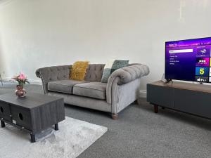 a living room with a couch and a flat screen tv at Spacious Family Friendly 4-Bed Holiday Home in Ilford