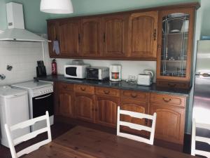 a kitchen with wooden cabinets and white appliances at Ancienne ecole de moncere in Penne +17 photos