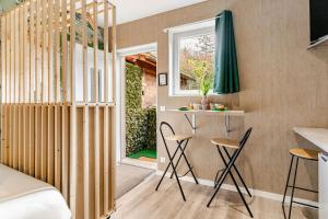 Zimmer mit einem Bett, Stühlen und einem Fenster in der Unterkunft Studio rénové au calme proche de Genève in Beaumont