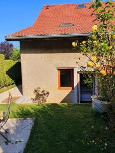 ein Haus mit einem roten Dach und einem grünen Hof in der Unterkunft Studio rénové au calme proche de Genève in Beaumont + 28 Fotos