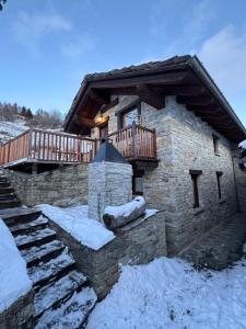 a log cabin in the snow with a deck at L'Atelier du Temps - Casa Torre in Challancin