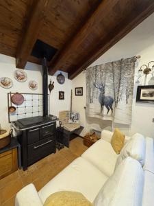 a living room with a white couch and a stove at L'Atelier du Temps - Casa Torre in Challancin