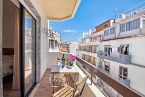 a balcony with a table and chairs in a building at Casa Santos in Monte Gordo