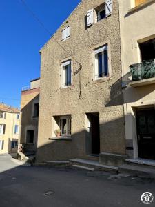 a building with a clock on the side of it at Chez madou in Roquefort-des-Corbières