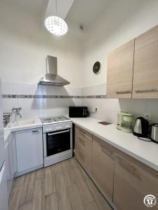 a kitchen with a stove and a sink at Chez madou in Roquefort-des-Corbières +3 photos