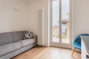 a living room with a couch and a window at GARDA LIVING APARTMENTS Torbole in Nago-Torbole