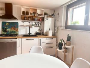 a kitchen with white cabinets and a white refrigerator at Sotto il Tetto con i Gatti in Lanciano +2 photos