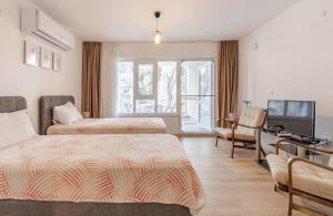 ein Hotelzimmer mit zwei Betten und einem Fernseher in der Unterkunft Güneş Villa Bahçe Katı in Antalya