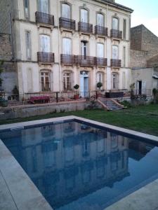 un edificio con una piscina di fronte a un edificio di La maison bachelet a Claira