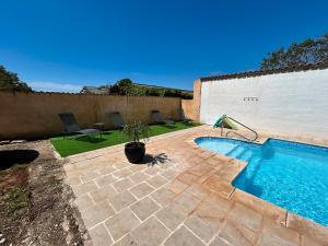 a swimming pool in a yard with chairs at Domaine des Oliviers - Les Borrels in Hyères