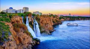 a boat in a river next to a waterfall at Güneş Villa Bahçe Katı in Antalya