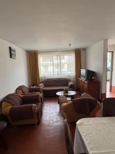 Una sala de estar con sillas, un sofá y una mesa. en Omar J House, en Paipa