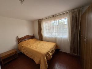 Un dormitorio con una cama frente a una ventana. en Omar J House, en Paipa