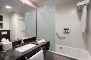 a white bathroom with a sink and a shower at Catalonia Málaga in Málaga