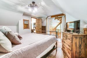 a bedroom with a bed and a television on a dresser at 5 Mi to Helen Hideaway with Deck and Grill! in Sautee Nacoochee