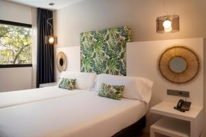 a bedroom with a white bed and a mirror at Catalonia Málaga in Málaga