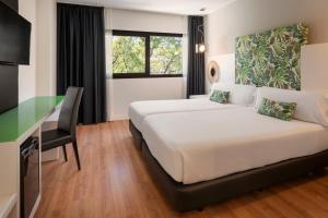 a hotel room with a bed and a desk at Catalonia Málaga in Málaga