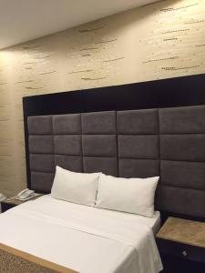 1 dormitorio con 1 cama blanca grande y cabecero en Rukon Buotat 15, en Riad