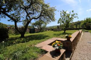 a bench with flowers on it in a park at South View Cottage Dacre in Dacre