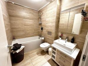 a bathroom with a sink and a toilet and a tub at Jupiter Suite #6people in Ştefăneştii de Sus