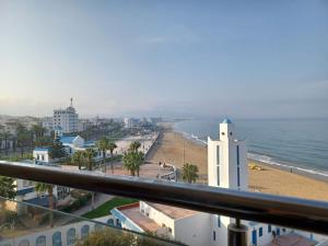 a view of a beach and the ocean from a balcony at Miramar in M'diq
