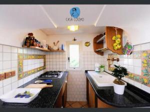 een keuken met een zwart aanrecht en een wastafel bij Cosimo's House Casa Cosimo in Atrani +7 foto's