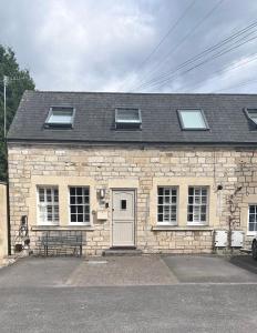 ein Steinhaus mit einer weißen Tür und Fenstern in der Unterkunft Bath Central Free Parking One Double Ensuite Room in Historical Mews Cottage in Bath