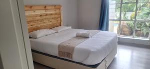 a bedroom with a large bed with a wooden headboard at Stylish 4-Bed Oasis - Pool Garden BackupPower in Johannesburg