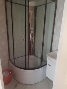 una doccia con box in vetro in un bagno di Divu istabu saulains dzīvoklis Ugālē a Ugāle