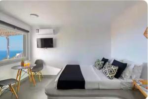a bedroom with a bed and a table with chairs at Doras studios mykonos in Fanari