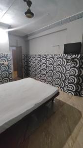 1 cama en una habitación con una pared con estampados en Shree Hariraj Guest House, en Jāmb