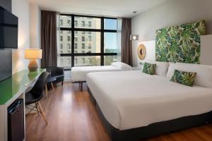 a hotel room with a bed and a desk at Catalonia Málaga in Málaga